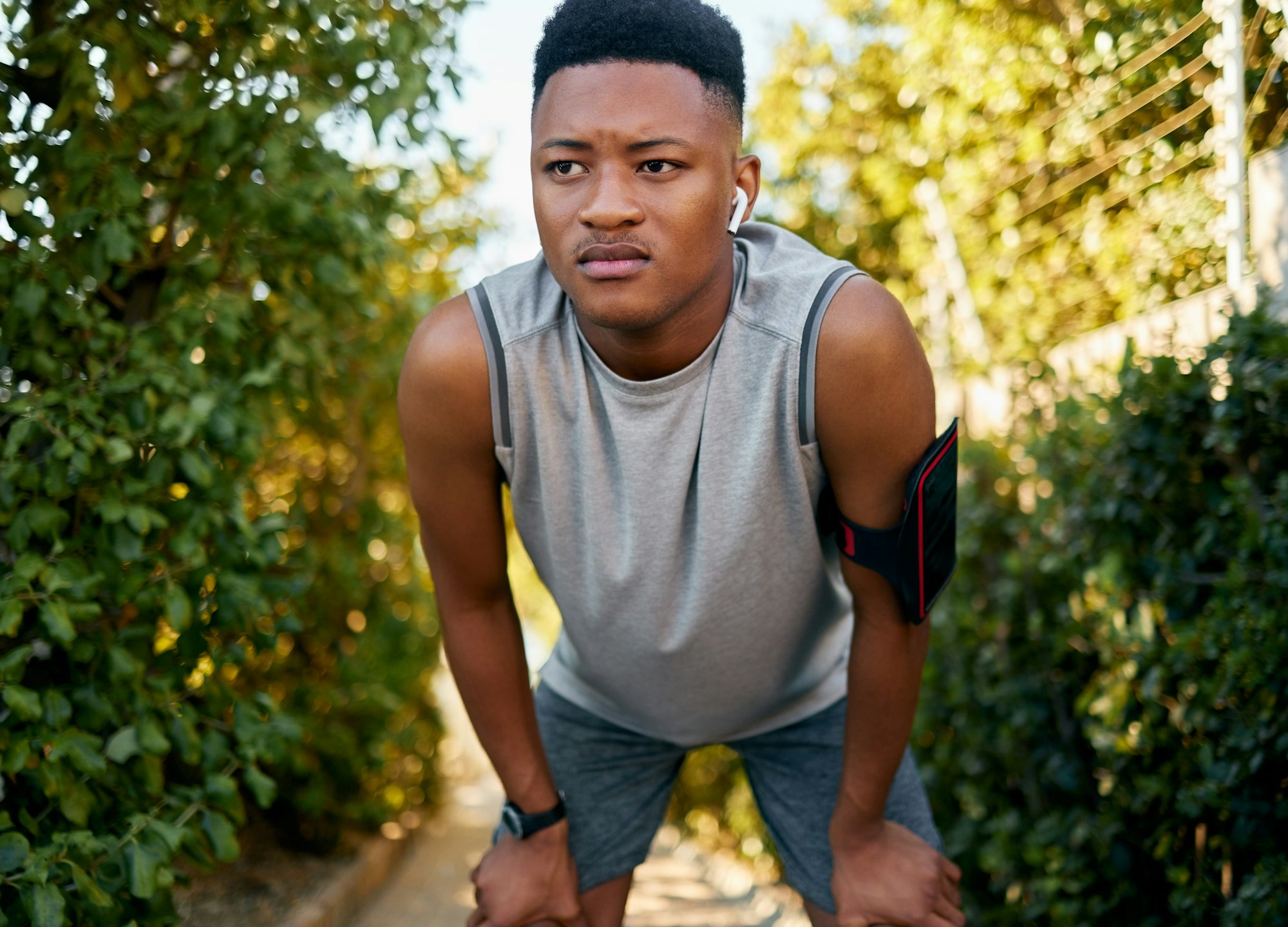 Fitness, running and tired with a sports black man outdoor during summer taking a break from a work